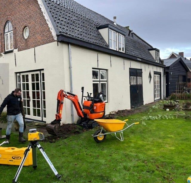 Julian met minigraver bij een woning