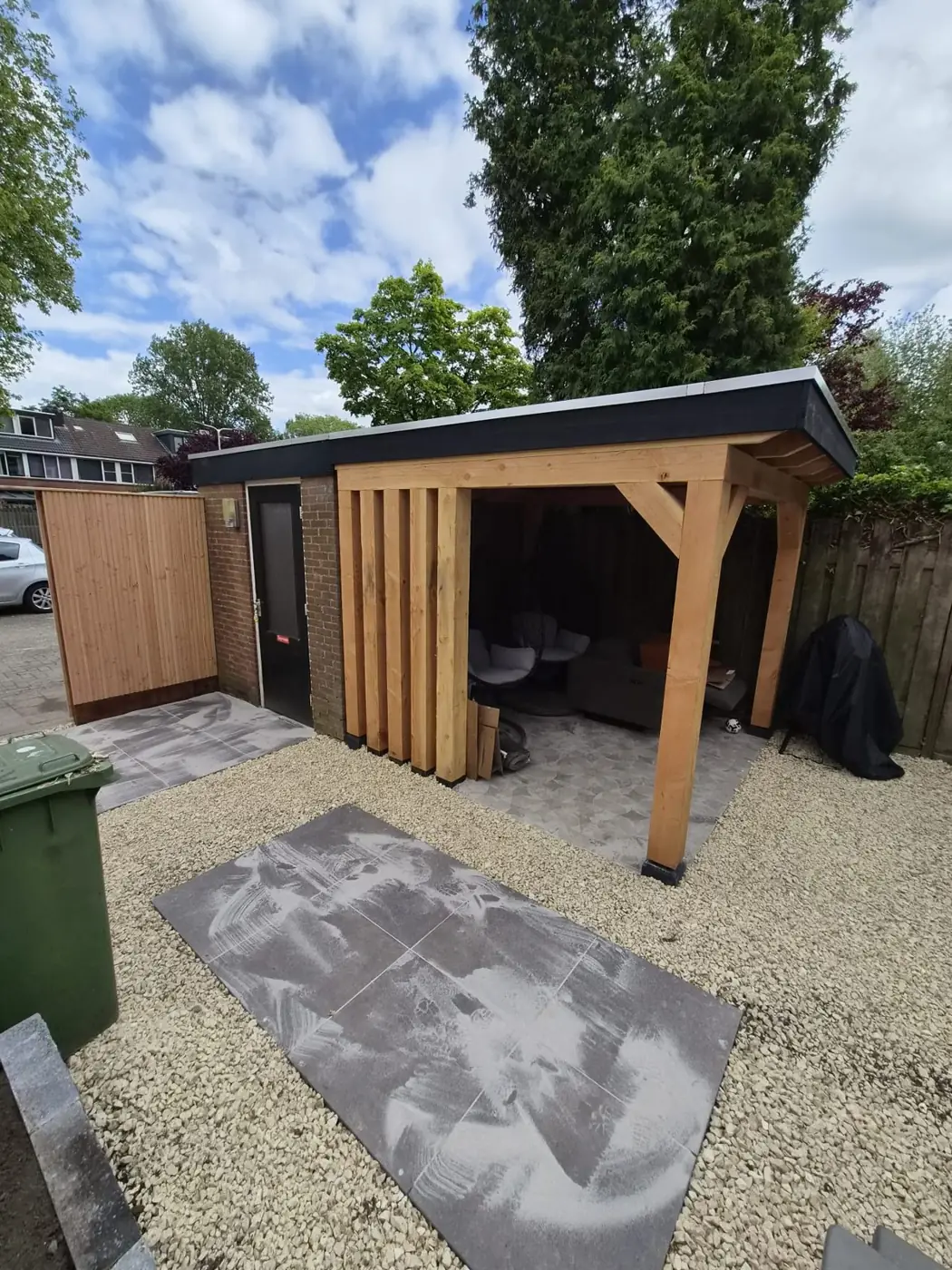 Achtertuin met overkapping en schutting